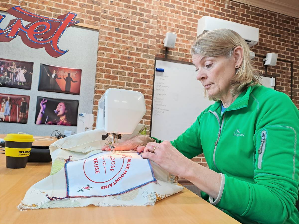 Alison sewing a label onto her boomerang bag.